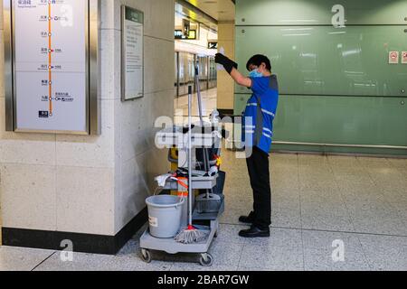 Hong Kong, Cina. 29 marzo 2020. Un addetto alla pulizia controlla la sua bottiglia di sanitize all'interno della stazione della metropolitana. Nelle ultime due settimane, il numero di infezioni da Covid-19 a Hong Kong è triplicato a più di 580, Hong Kong ha imposto un nuovo divieto a gruppi di più di quattro persone in pubblico, dimezzando la capacità dei ristoranti e chiudendo sei tipi di locali per il tempo libero per 14 giorni. Credit: Keith Tsuji/ZUMA Wire/Alamy Live News Foto Stock