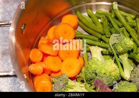 Preparazione di verdure fresche per la cena durante il blocco per il coronavirus, tenendo occupato mentre limitato in uscita a causa di Covid-19, Northampto Foto Stock