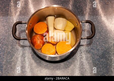Preparazione di verdure fresche per la cena durante il blocco per il coronavirus, tenendo occupato mentre limitato in uscita a causa di Covid-19, Northampto Foto Stock