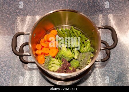 Preparazione di verdure fresche per la cena durante il blocco per il coronavirus, tenendo occupato mentre limitato in uscita a causa di Covid-19, Northampto Foto Stock