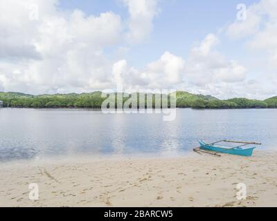 Antenna di 'Secret Beach' con una barca di pescatori su di essa e la foresta di mangrovie in una distanza Foto Stock