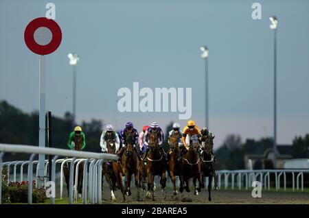 I corridori e i piloti si prendono la prima curva durante la schiena o si stendono a betdaq.com Claiming Stakes sulla pista All Weather all'ippodromo di Kempton Foto Stock