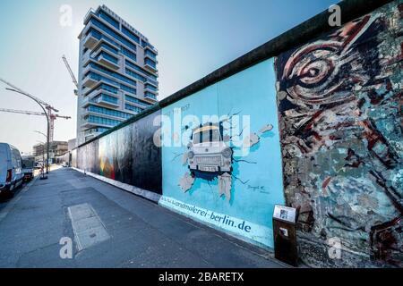 Berlino, Germania. 26 marzo 2020. 26.03.2020, il monumento della East Side Gallery nella sezione più lunga del Muro di Berlino in Muhlenstrasse tra Berlino Ostbahnhof e Oberbaumbrucke lungo la Sprea a Berlino-Friedrichshain. Presenta una galleria permanente all'aperto con opere di vari artisti. Ecco l'opera 'PROVA IL RESTO' dell'artista Birgit Kinder, che mostra un Trabant che passa attraverso il muro attraverso di voi. --- solo per uso editoriale! --- solo per uso editoriale! --- | utilizzo nel mondo Credit: dpa/Alamy Live News Foto Stock