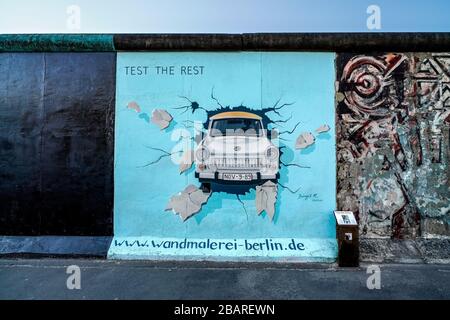 Berlino, Germania. 26 marzo 2020. 26.03.2020, il monumento della East Side Gallery nella sezione più lunga del Muro di Berlino in Muhlenstrasse tra Berlino Ostbahnhof e Oberbaumbrucke lungo la Sprea a Berlino-Friedrichshain. Presenta una galleria permanente all'aperto con opere di vari artisti. Ecco l'opera 'PROVA IL RESTO' dell'artista Birgit Kinder, che mostra un Trabant che passa attraverso il muro attraverso di voi. --- solo per uso editoriale! --- solo per uso editoriale! --- | utilizzo nel mondo Credit: dpa/Alamy Live News Foto Stock