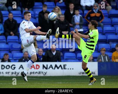 L-R; Jake Cassidy di Tranmere Rovers e ed Upson di Yeovil Town combattono per il possesso della palla in aria Foto Stock