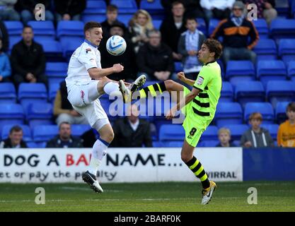 L-R; Jake Cassidy di Tranmere Rovers e ed Upson di Yeovil Town combattono per il possesso della palla in aria Foto Stock