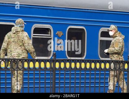 Kiev, Ucraina. 29 marzo 2020. Gli ucraini evacuati in treno dalla Russia, a causa della diffusione del coronavirus COVID-19, attendono di lasciare un treno all'arrivo alla stazione centrale di Kiev, Ucraina, il 29 marzo 2020. I cittadini ucraini che, a causa di misure restrittive in relazione alla quarantena a causa del coronavirus diffuso COVID-19 non sono in grado di attraversare il confine, sono stati evacuati dal treno speciale dalla Russia. Credit: Serg Glovny/ZUMA Wire/Alamy Live News Foto Stock