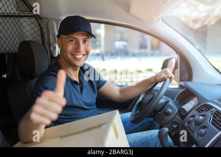 Sorridente uomo di consegna con il suo furgone Foto Stock