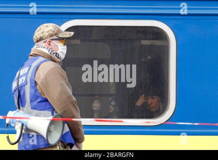 Kiev, Ucraina. 29 marzo 2020. Una donna Ucraina evacuata in treno dalla Russia, a causa della diffusione del coronavirus COVID-19, attende di lasciare un treno all'arrivo alla stazione centrale di Kiev, Ucraina, il 29 marzo 2020. I cittadini ucraini che, a causa di misure restrittive in relazione alla quarantena a causa del coronavirus diffuso COVID-19 non sono in grado di attraversare il confine, sono stati evacuati dal treno speciale dalla Russia. Credit: Serg Glovny/ZUMA Wire/Alamy Live News Foto Stock