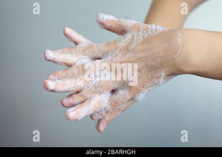 Lavaggio delle mani con sapone schiumoso, protezione contro il coronavirus. Primo piano Foto Stock