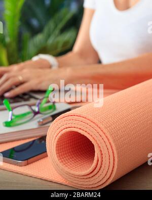 Concetto di business e stile di vita sano. Tappetino per lo yoga sulla scrivania, vista dall'alto, indossabile da donna sul posto di lavoro Foto Stock