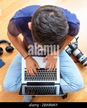 Ufficio domestico, lavoro a distanza. Giovane uomo che lavora con un computer portatile. Telelavoro, telelavoro, lavoro da casa, uso di Internet, e-mail e t Foto Stock