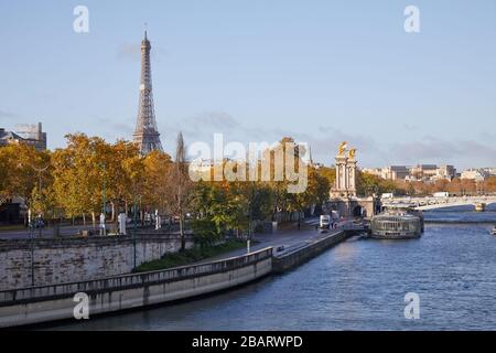 Vista sulla Senna con banchine, Torre Eiffel e Ponte Alexander III in una giornata di autunno soleggiata a Parigi Foto Stock