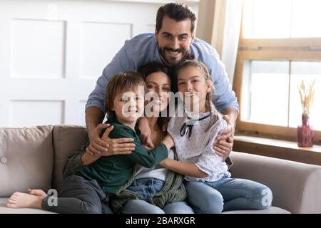 Sorridente amorevole famiglia piena posa per la foto in soggiorno. Foto Stock