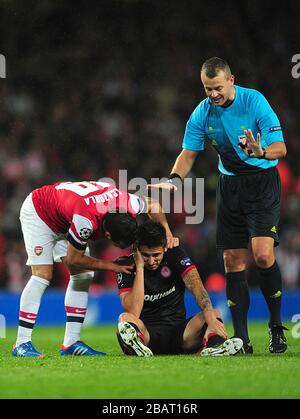 Arsenals Santi Cazorla (a sinistra) parla con Leandro Greco (al centro) dell'Olympiakos mentre l'arbitro Svein Oddvar Moen guarda Foto Stock