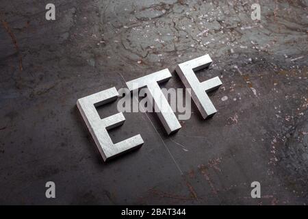 L'abbreviazione etf - Exchange Traded Fund - Laid with silver letters on raw arruggined steel sheet surface in slangted diagonali perspective. Foto Stock