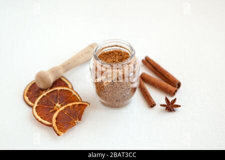 Bastoncini di cannella e anice stellato su zucchero di canna con profondità di campo bassa su sfondo bianco. Cottura degli ingredienti Foto Stock