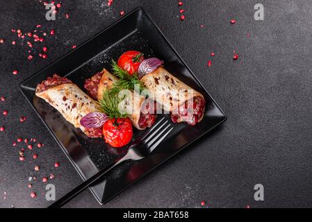 Delizioso tartaro di manzo fresco con toast su un piatto quadrato nero su sfondo scuro Foto Stock