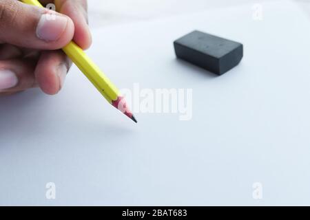 Primo piano di scrittura maschile a mano con matita su carta Foto Stock