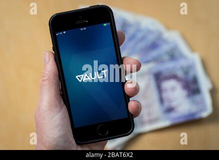 Una donna che utilizza l'app DeVere Vault su un telefono cellulare. (Solo per uso editoriale) Foto Stock