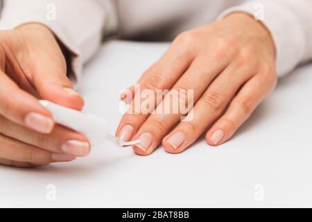 primo piano donna verniciatura unghie a casa. autorigunghia rafforzamento in quarantena Foto Stock