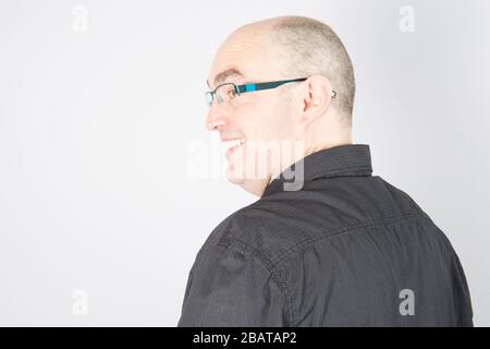 Primo piano scatto studio di bald felice sorridente uomo sicuro con occhiali Foto Stock