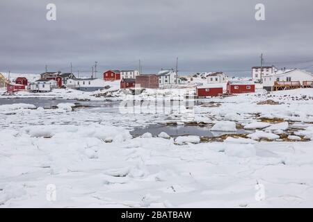 Palchi e case lungo il ghiacciato porto basculante nel villaggio di pescatori storico di basculamento, sull'isola di Fogo in Terranova, Canada Foto Stock