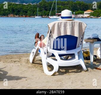 Un uomo che si rilassa su un lettino sulla spiaggia presso l'hotel Tui Sensimar Kalamota Island Resort, Koločep, Isole Elaphiti, Croazia, Europa Foto Stock