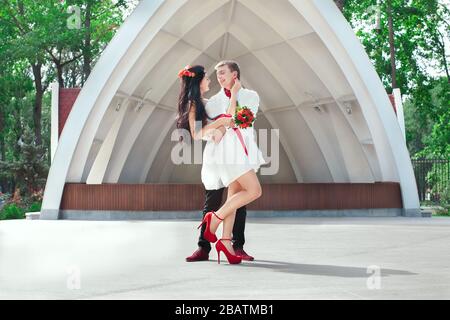 Sposa e sposo che si posano nel parco divertimenti Foto Stock