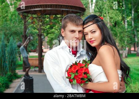 Sposa e sposo che si posano nel parco divertimenti Foto Stock