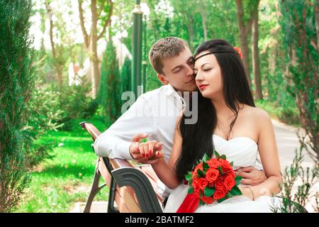 Sposa e sposo che si posano nel parco divertimenti Foto Stock