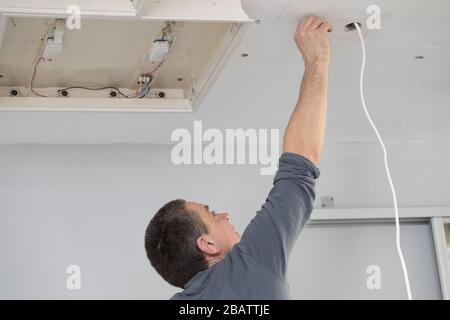 Ogni elettricista, anche con molta esperienza, è dotato di un cavo ad angolo per le scosse elettriche, quindi è sempre in guardia. Foto Stock