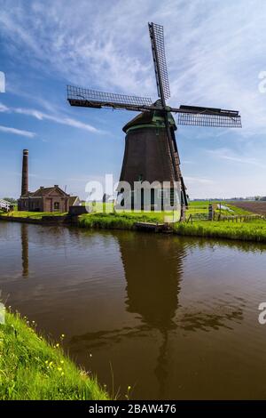 Il mulino a vento De Kaagmolen di fronte ad un canale e ad una barca (comune di OPmeer, Olanda del Nord, Paesi Bassi) Foto Stock