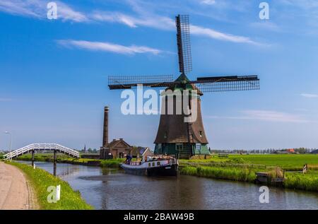 Il mulino a vento De Kaagmolen di fronte ad un canale e ad una barca (comune di OPmeer, Olanda del Nord, Paesi Bassi) Foto Stock