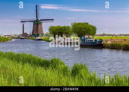 Il mulino a vento De Kaagmolen di fronte ad un canale e ad una barca (comune di OPmeer, Olanda del Nord, Paesi Bassi) Foto Stock