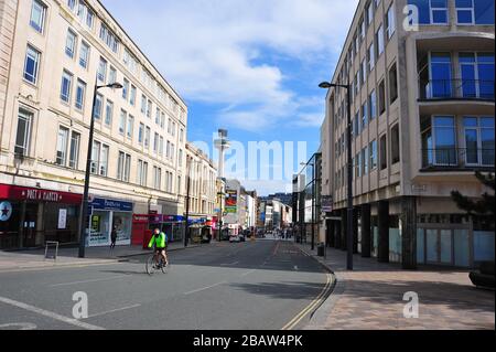 Derby Park a Bootle Liverpool è quasi deserta e l'area giochi per bambini è chiusa. La gente tiene la loro distanza al supermercato a causa di COVID-19. Foto Stock