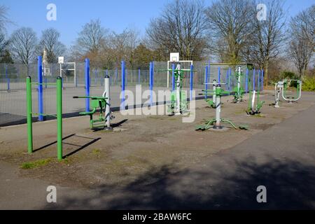 Derby Park a Bootle Liverpool è quasi deserta e l'area giochi per bambini è chiusa. La gente tiene la loro distanza al supermercato a causa di COVID-19. Foto Stock