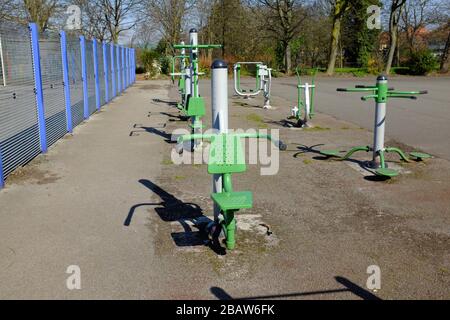 Derby Park a Bootle Liverpool è quasi deserta e l'area giochi per bambini è chiusa. La gente tiene la loro distanza al supermercato a causa di COVID-19. Foto Stock