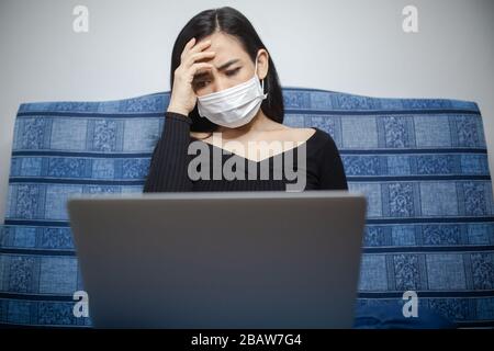 Epidemia di coronavirus: Una donna che legge notizie/aggiornamenti sul coronavirus e che riceve ansia/depressione. Isolamento contro Coronavirus. Foto Stock
