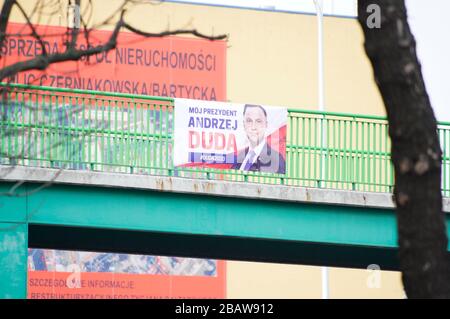 Un banner che pubblicizza la candidatura del presidente in carica Andrzej Duda alle prossime elezioni presidenziali si trova nel centro di Varsavia, in Polonia, il 29 marzo 2020. Il 24 marzo il governo polacco ha annunciato ulteriori restrizioni al movimento personale dopo aver già chiuso scuole, bar e ristoranti, oltre a chiudere i confini agli stranieri. Le riunioni di più di due persone sono vietate in pubblico fino all'aprile 11. Nonostante le misure più severe, il partito della legge e della giustizia ha modificato le regole elettorali in modo che le elezioni presidenziali del maggio 10 rimani in vigore. Foto Stock