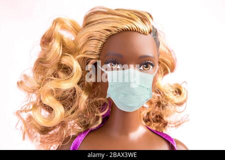 Bambola afro-americana con composizione protettiva della maschera medica concetto creativo minimo. Foto Stock