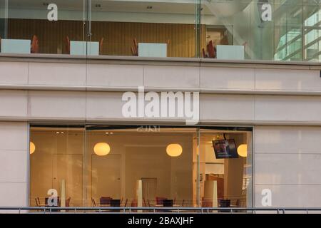 Breaking TV news that UK prime Minister Boris Johnson tests positive for COVID-19 on TV screen in ufficio vuoto a Canary Wharf che è chiuso a causa di n Foto Stock