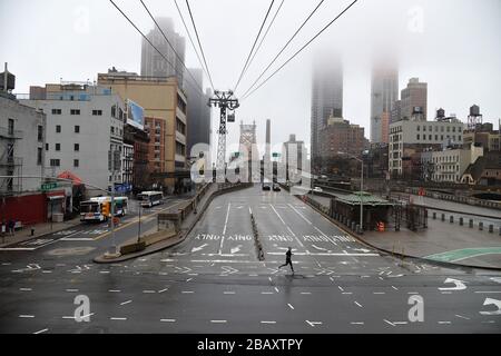 New York, Stati Uniti. 29 marzo 2020. Un uomo è visto correre lungo la 2a Avenue dopo la rampa di uscita di Manhattan del ponte ed Koch 59th Street con neary tutto il traffico a New York, NY, 29 marzo 2020. Il Center for Disease Control (CDC) ha pubblicato un avviso di viaggio nazionale per New York, New Jersey e Connecticut, chiedendo ai residenti nell'area tri-state di New York di astenersi dal viaggio locale non essenziale, New York, NY, 29 marzo 2020. (Anthony Behar/Sipa USA) Credit: Sipa USA/Alamy Live News Foto Stock