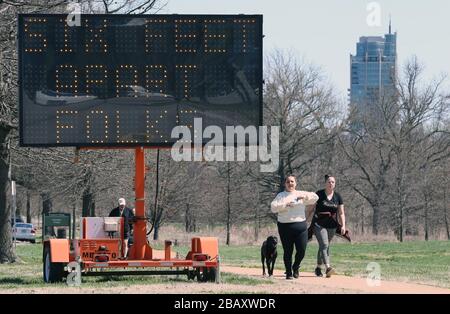 St. Louis, Stati Uniti. 29 marzo 2020. Le indicazioni stradali ricordano ai visitatori del Forest Park, per mantenere la loro distanza di circa 6 metri, a St. Louis domenica 29 marzo 2020. A causa delle paure di Coronavirus, l'uso di strutture ricreative è stato ulteriormente limitato come la città di St. Louis lavora per prevenire la diffusione del virus. L'ordine diretto il 29 marzo 2020 dice che tutti i campi da tennis, campi da pallacanestro, campi da racquetball o da pallamano, campi da pickleball e piste da roller sono ora chiusi al pubblico fino al 22 aprile al più presto. Foto di Bill Greenblatt/UPI Credit: UPI/Alamy Live News Foto Stock