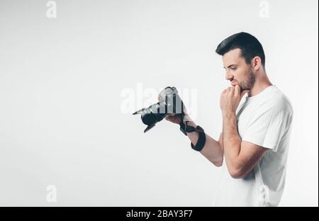 Fotografo professionista guardare schermo e pensare. Dopo aver fotografato utilizzando attrezzature fotografiche professionali. Thouhtful uomo calmo e pacifico Foto Stock