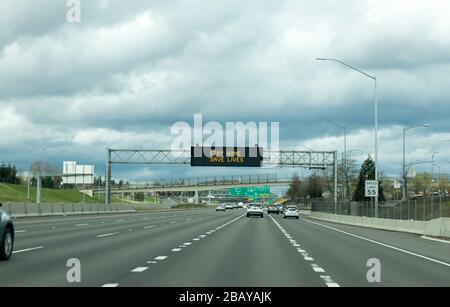 Portland, OR / USA - 29 marzo 2020: Segnale elettronico sulla superstrada I205 che informa le persone di rimanere a casa e salvare vite umane riducendo il rischio di essere infettante Foto Stock