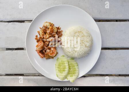 Aglio Pesce fritto / gamberi fritti calamari con riso su piatto bianco e cetriolo , vista dall'alto Foto Stock