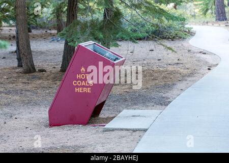 Bidone per lo smaltimento del carbone caldo in un'area ombreggiata di giorno al lago tahoe Foto Stock