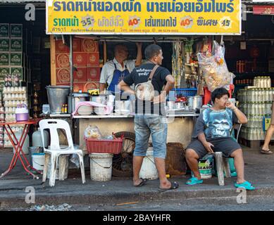 AYUTTHAYA, THAILANDIA, 27 GENNAIO 2020, il venditore di strada offre cibo tailandese - noodle fritto con maiale e un kale immerso nel sugo. Foto Stock