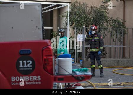 I vigili del fuoco di Barcellona disinfettano una residenza dove ci sono stati morti di coronavirus e alcuni positivi. Foto Stock